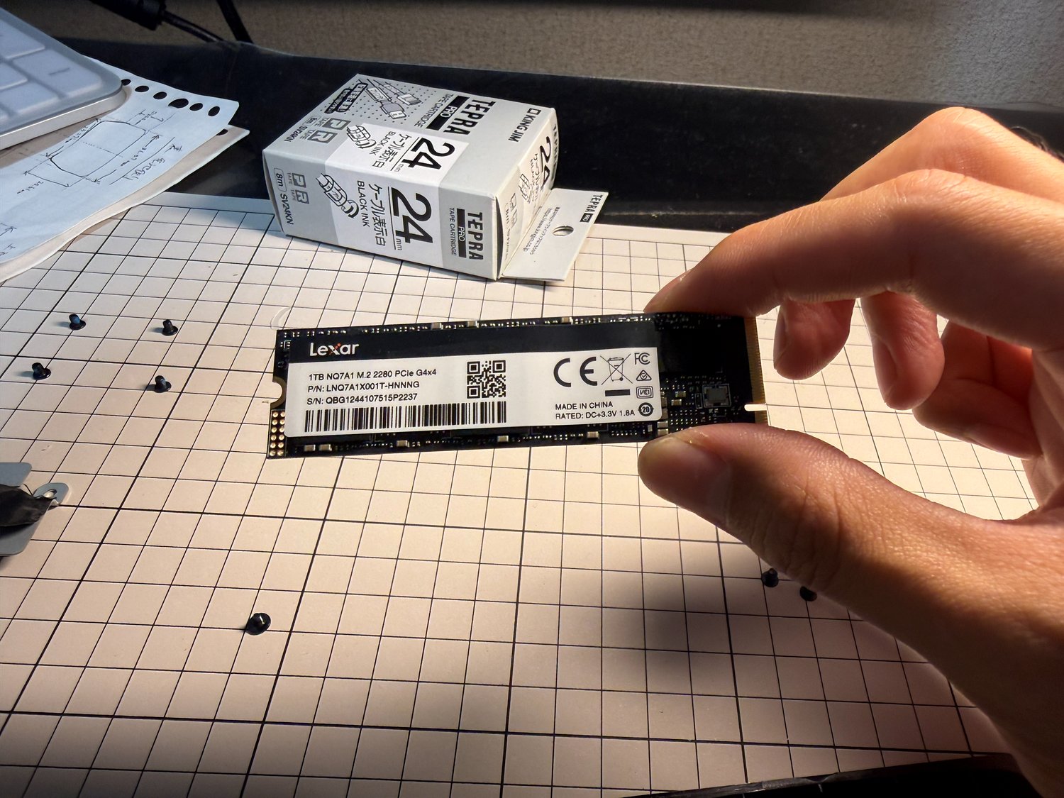 取り外したLexarのM.2 SSD（NQ7A1 1TB）を手に持った写真