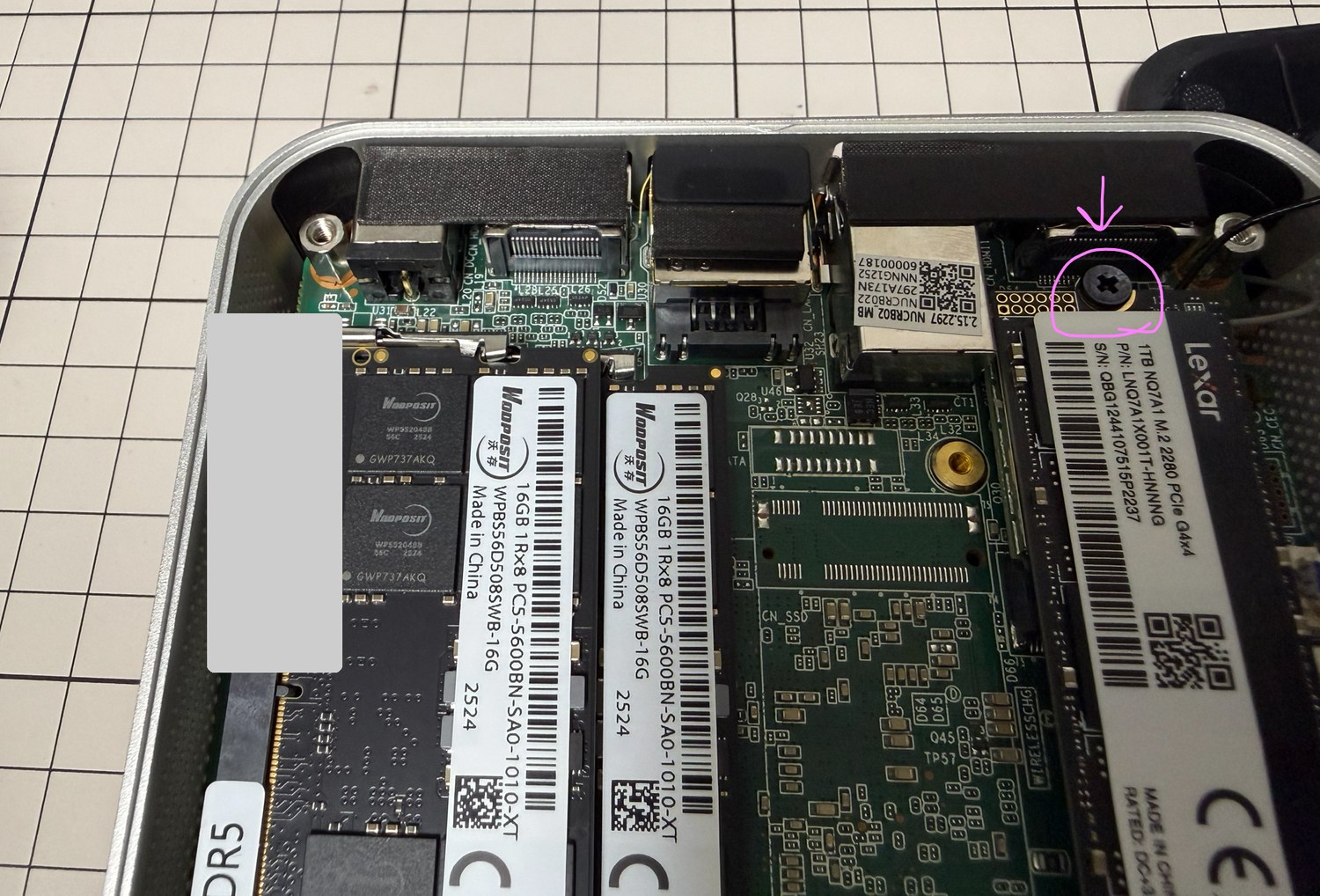 M.2 SSDを固定しているネジの位置をピンクの丸と矢印で示した写真