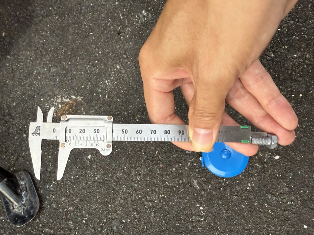 ノギスで端子ボルトのねじ部の長さを測っているところ