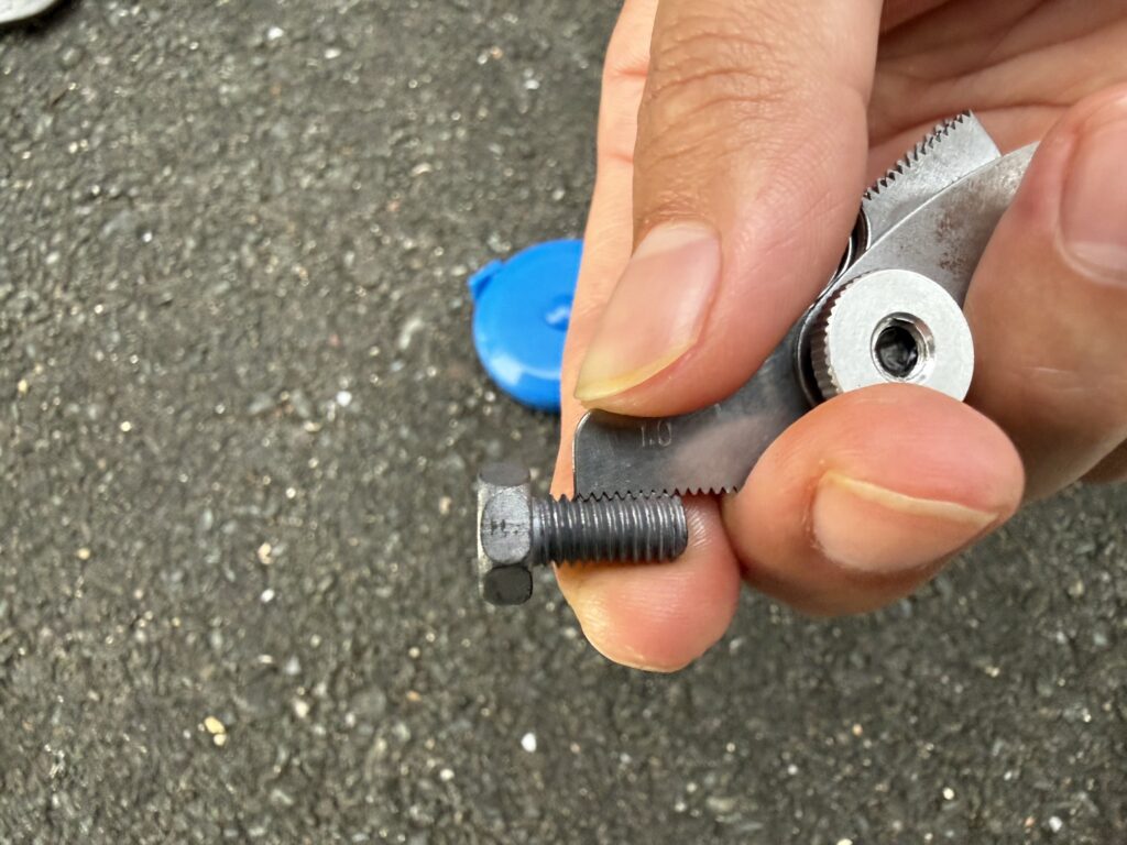 ピッチゲージで端子ボルトのねじピッチを確かめているところ