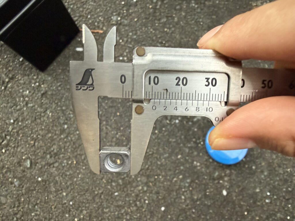 ノギスで四角いナットの長さを測っているところ